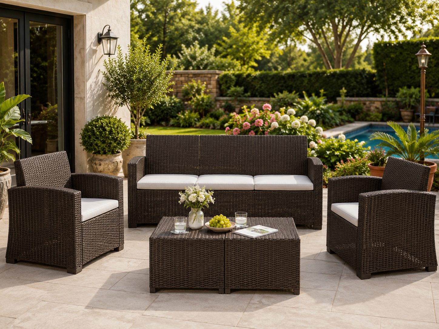 Home Wicker outdoor patio lounge set with cream cushions beside a garden pool